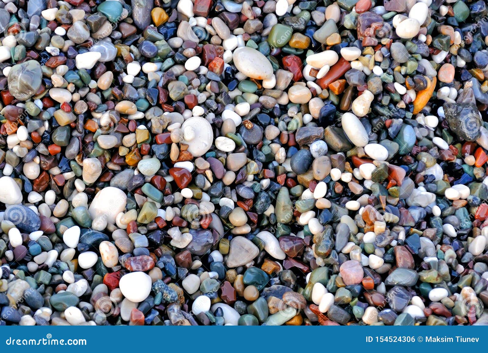 beautiful texture of wet multicolored pebbles on the sea shore, a unique pattern for , background, wallpaper